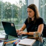 Eine Mitarbeiterin entwickelt im Büro eine Lösung zur Automatisierung von Arbeitsprozessen.